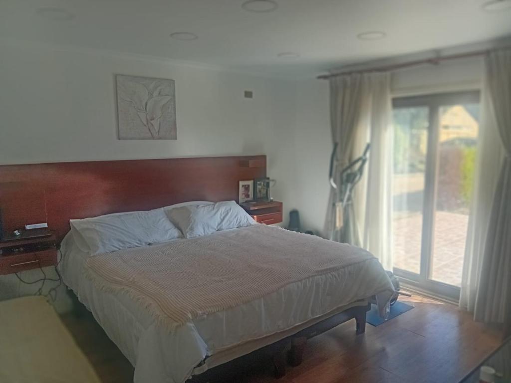 a bedroom with a bed and a large window at Parcela de agrado en Rocas de santo domingo in Santo Domingo