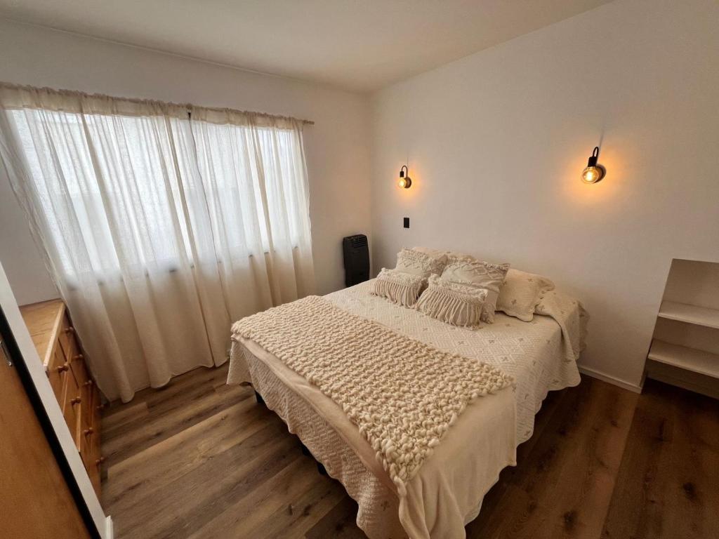 une chambre avec un lit et une grande fenêtre dans l'établissement Departamento Centro Bariloche, à San Carlos de Bariloche