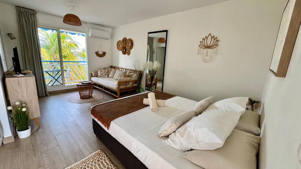 a bedroom with a bed and a living room at L'Escale - vue mer avec cuve in Saint-François