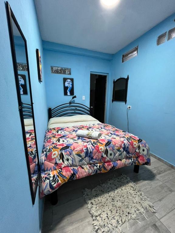 a bedroom with a bed with a blue wall at Dormis Totoral in Villa del Totoral