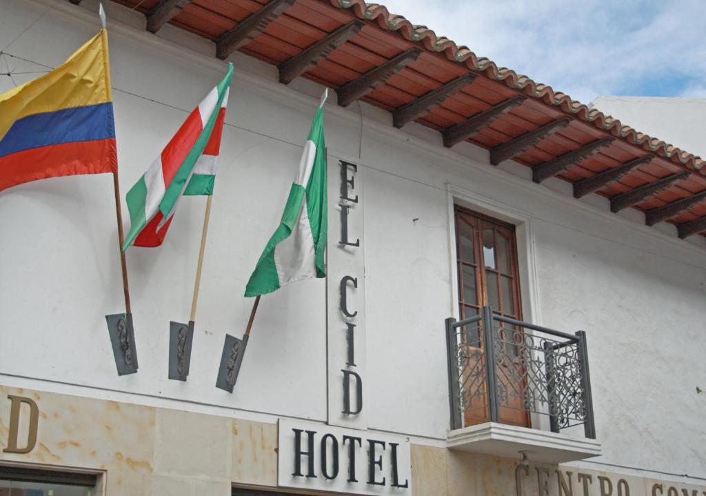 a group of flags on the side of a hotel at Hotel El Cid Plaza Premium in Tunja