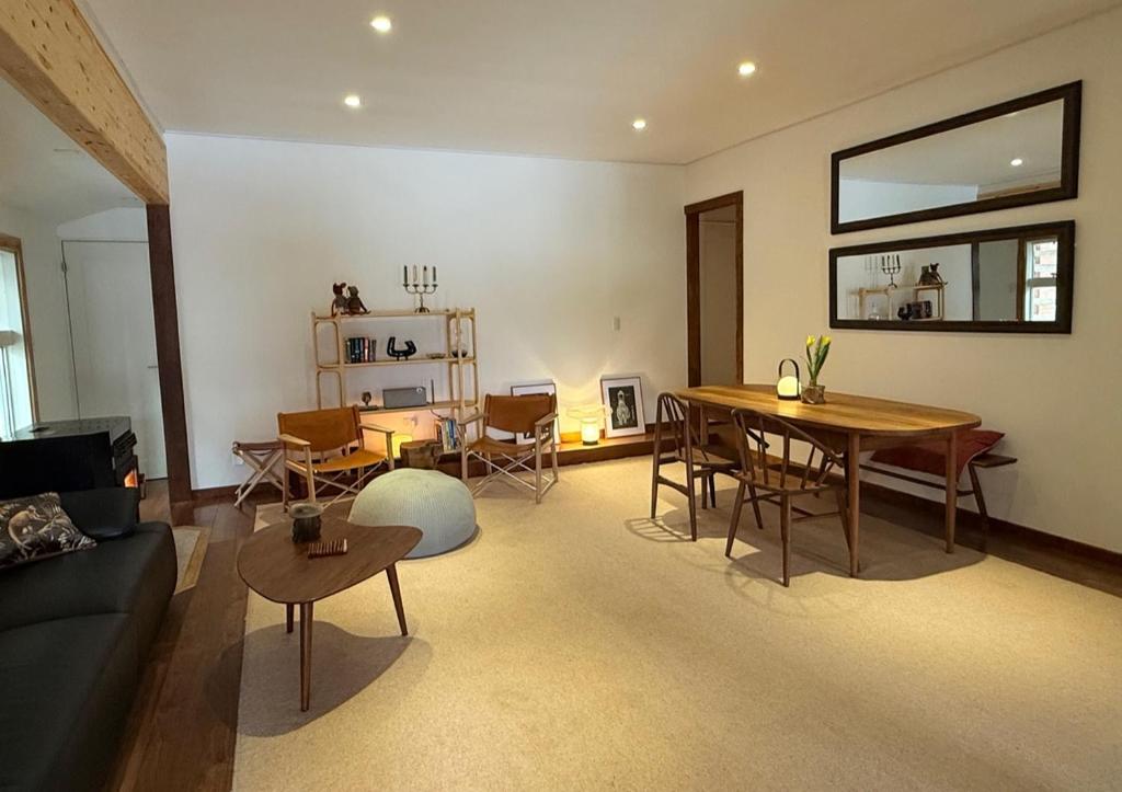 a living room with a couch and a table and chairs at My Chalet Hakuba in Hakuba