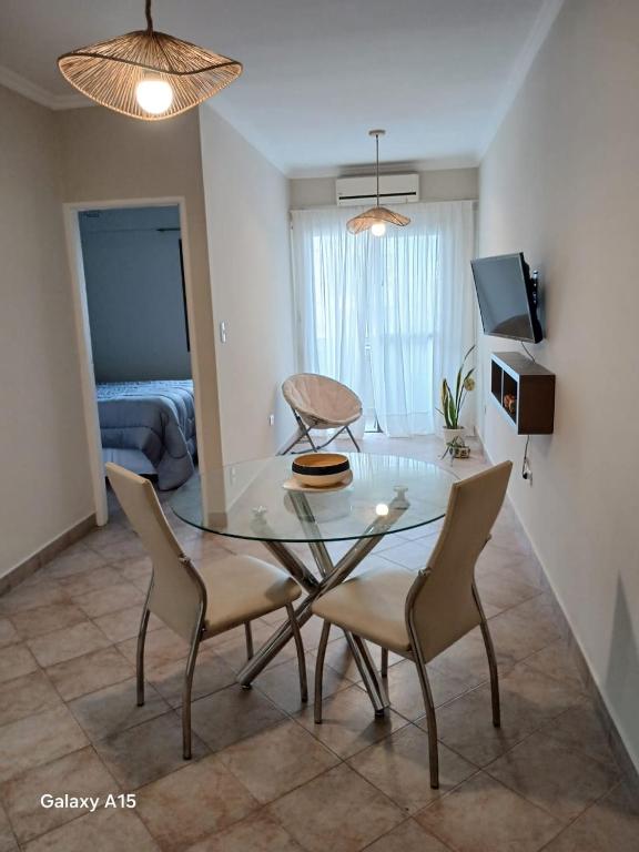 a dining room with a glass table and chairs at Flor de Liz in San Miguel de Tucumán