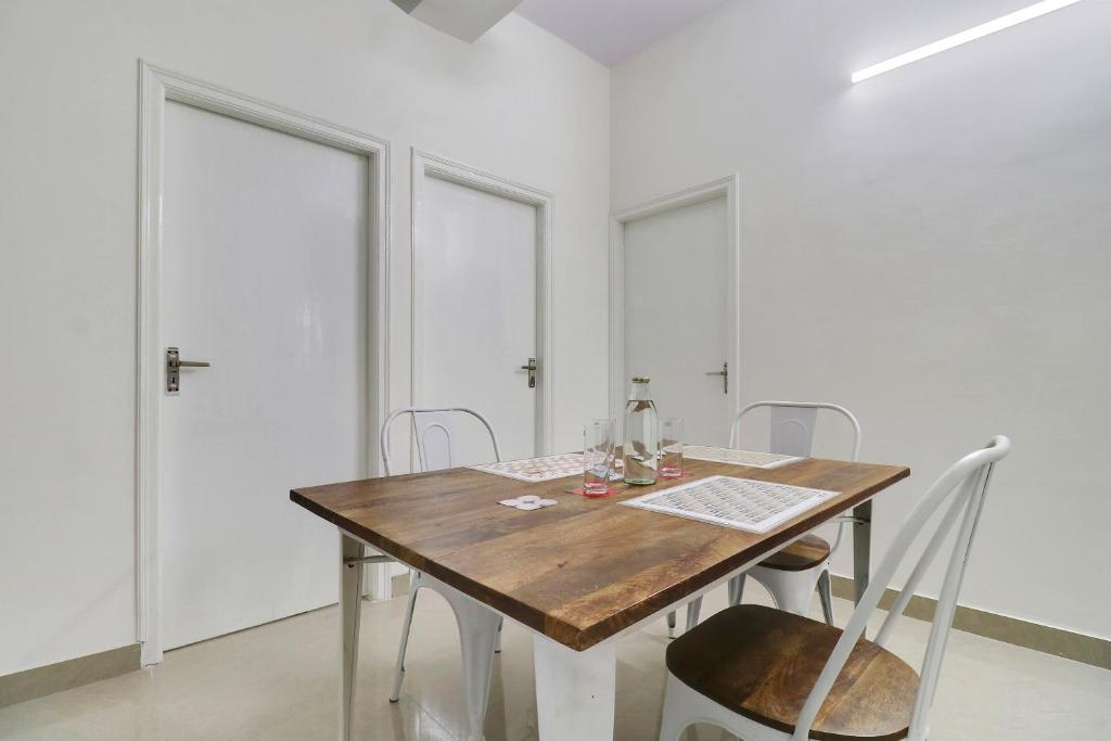 a dining room with a wooden table and chairs at Hotel O Leva Homes Near Baiyappanahalli Metro Station in Bengaluru