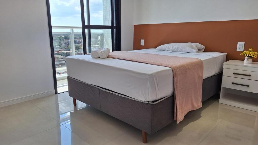 a bedroom with a large bed and a large window at Conforto e praticidade em região central de Belém in Belém