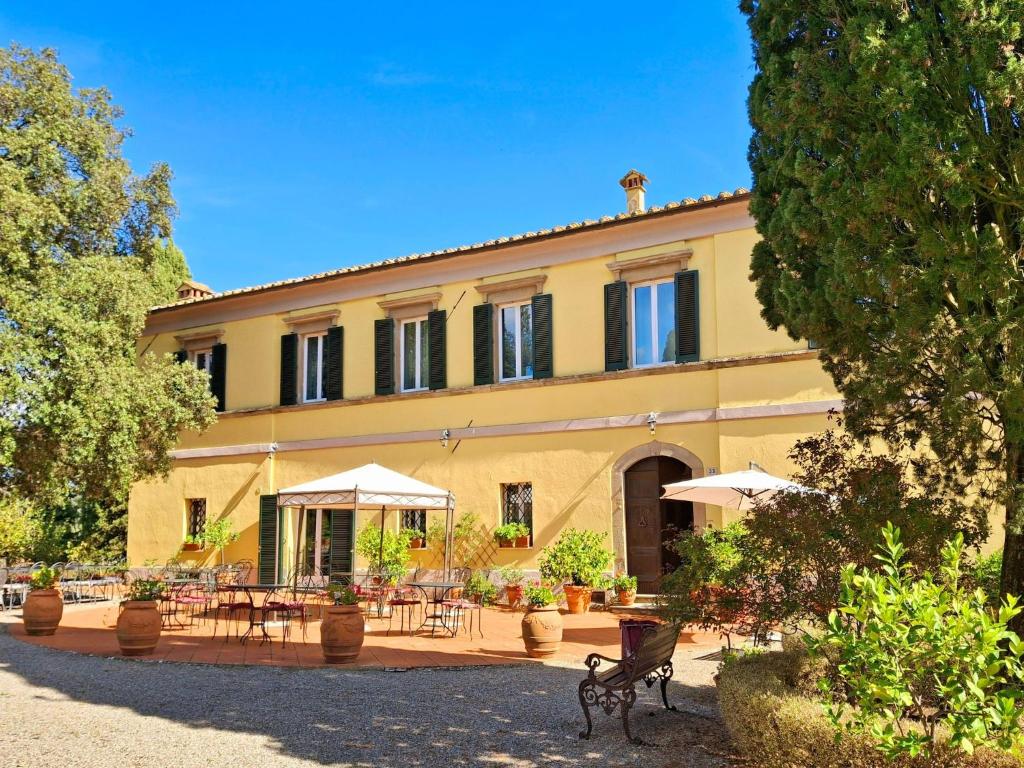 a building with tables and umbrellas in front of it at Spacious Holiday Home in Radicofani in Celle sul Rigo