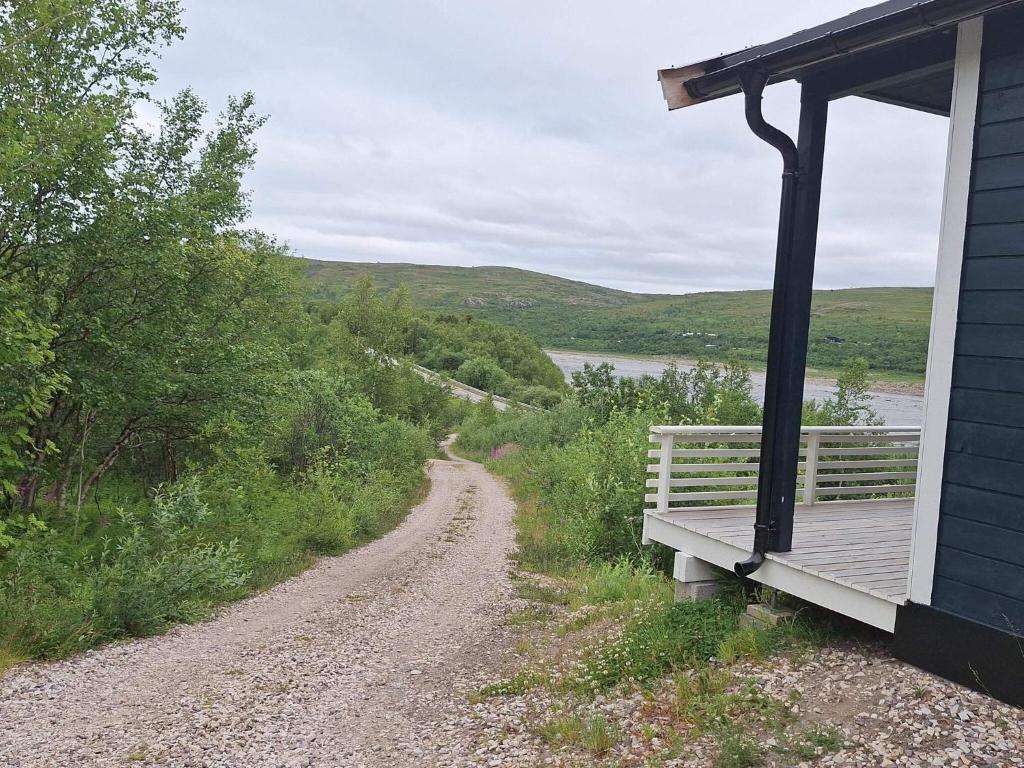 Tanaにある4 person holiday home in TANAのポーチのある家の隣の未舗装道路