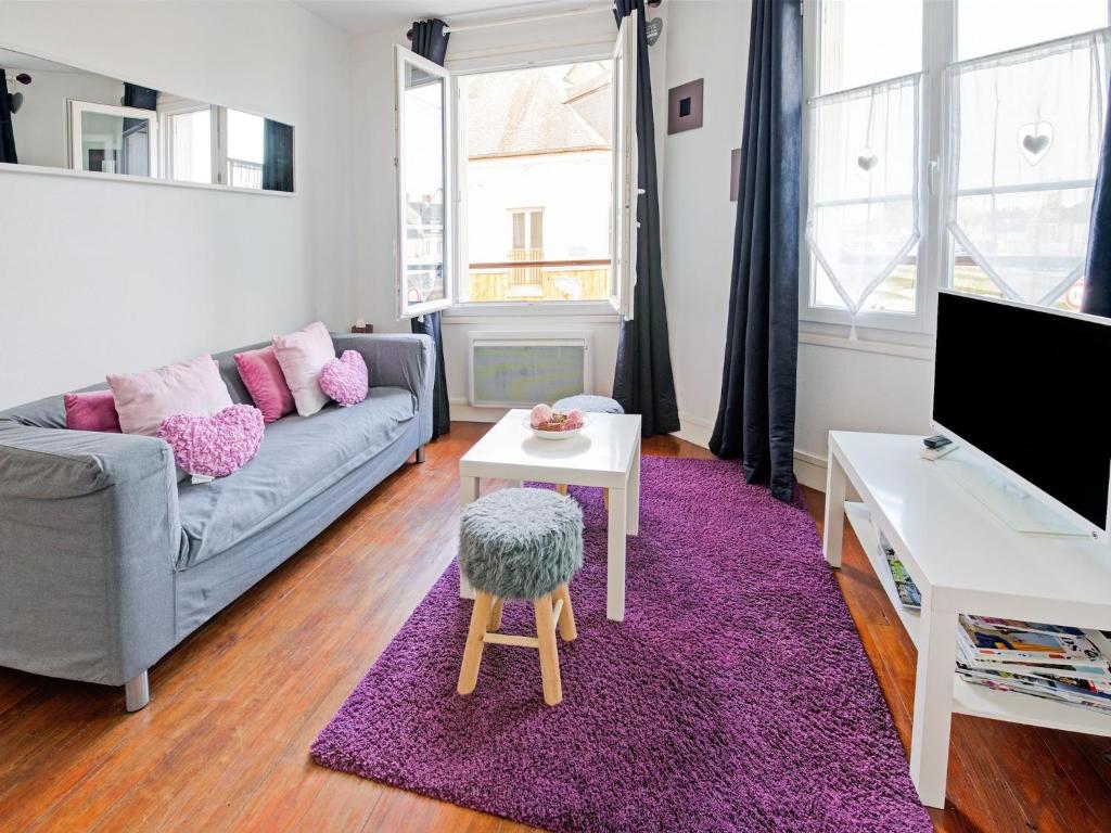 een woonkamer met een bank en een paars tapijt bij Harbor View Hideaway in Isigny-sur-Mer