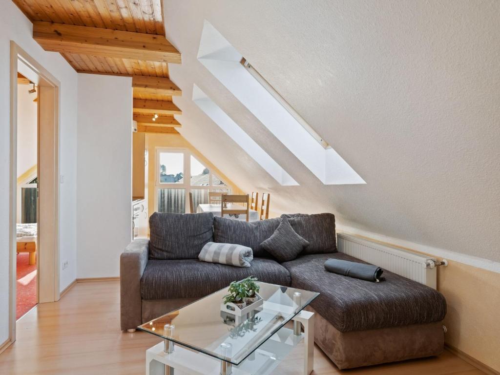 una sala de estar con un sofá y una mesa en Attic Apartment with Garden Access, en Gross Schwansee