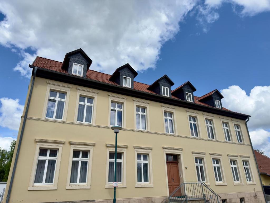 a large yellow building with a red roof at Ferienwohnung im Zentrum von Ballenstedt in Ballenstedt