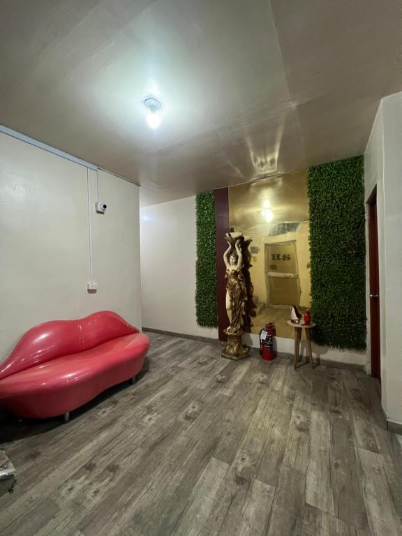 a room with a red couch and green walls at Hostal Las Vegas in Lima