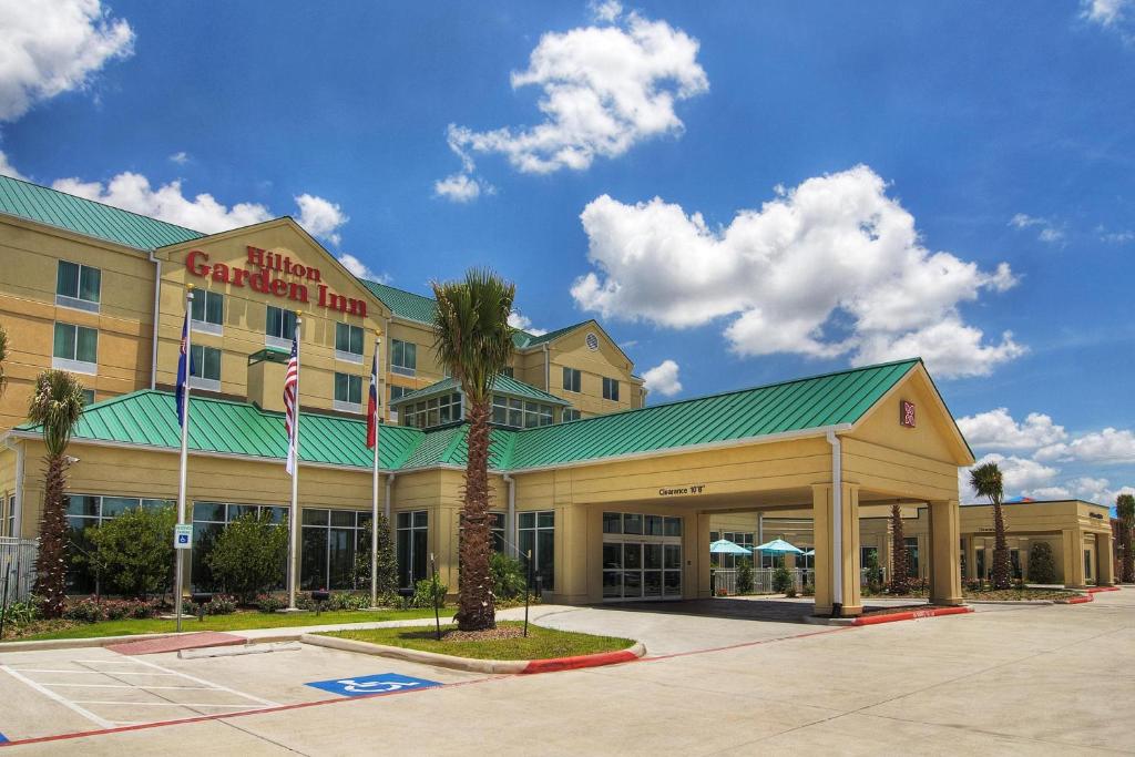 Un edificio de hotel con una palmera delante. en Hilton Garden Inn Houston-Pearland, en Pearland