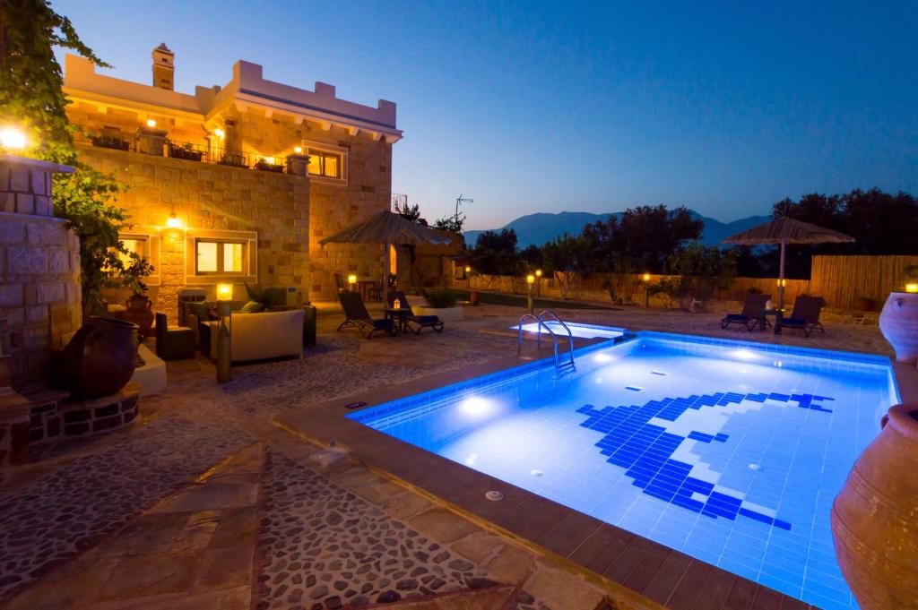 a swimming pool in front of a house at night at Nikolas country villa-anesis family in Kamilari