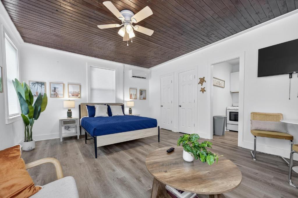 Un dormitorio con una cama azul y un ventilador de techo. en Pensacola Cozy Studio, en Pensacola