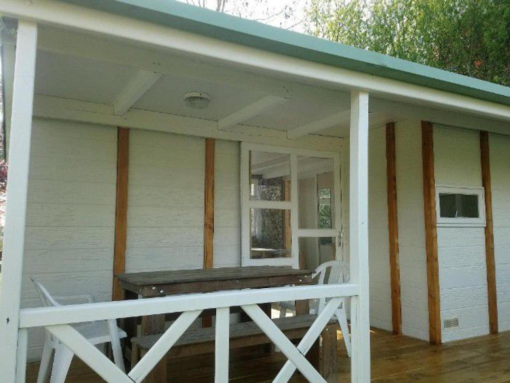 une terrasse couverte à l'avant d'une maison blanche avec terrasse dans l'établissement Chalet 6 pers avec Terrasse - Cuisine équipée - API-1-52-539, à Dévillac