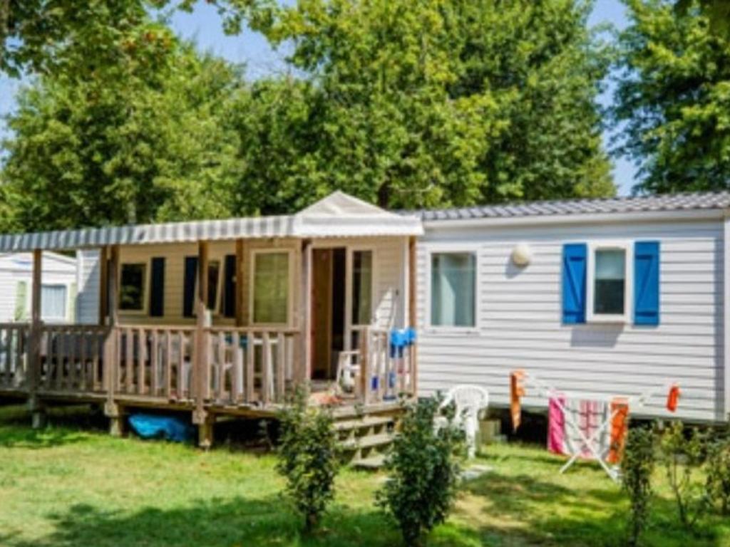 a tiny house with a porch and a deck at Mobil-home 33m² avec Terrasse - 3 Chambres - API-1-52-682 in Sainte-Eulalie-en-Born
