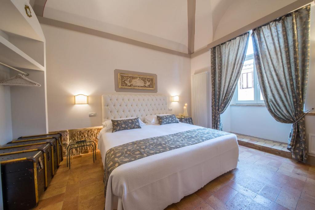 a bedroom with a bed and a chair in a room at Suite Assisi in Assisi