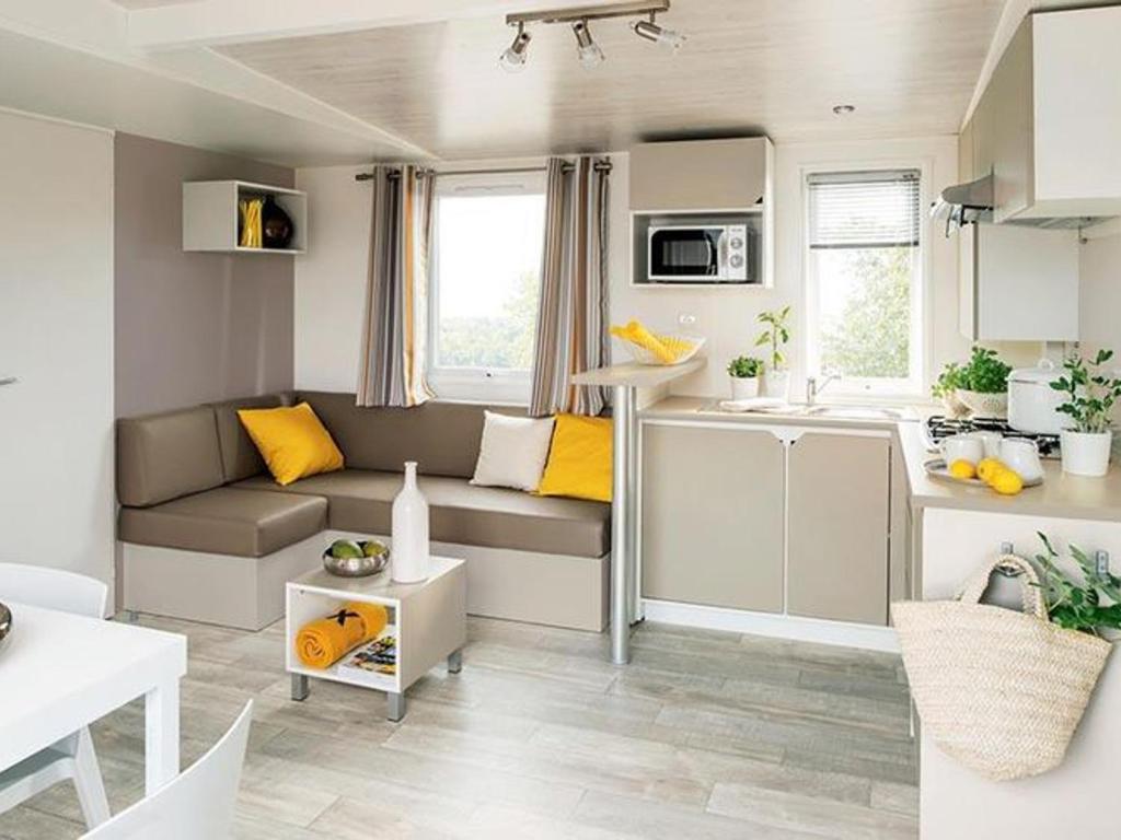 a small kitchen and living room in a caravan at Mobil-home 6 pers. avec Terrasse - API-1-52-774 in Saint-Gildas-de-Rhuys