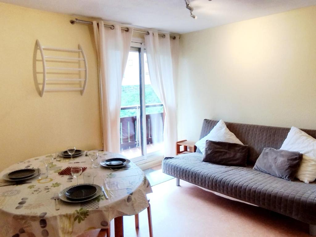 a living room with a couch and a table at 2 Pièces, skis aux pieds, proche commerces avec balcon. Capacité 6 pers, animaux non admis - FR-1-771-11 in Les Adrets