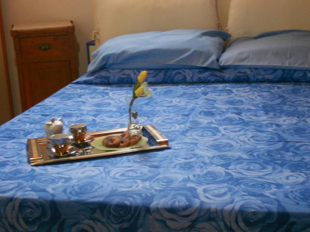 bandeja de comida en una cama con colcha azul en Piccola Azzurra en Comiso