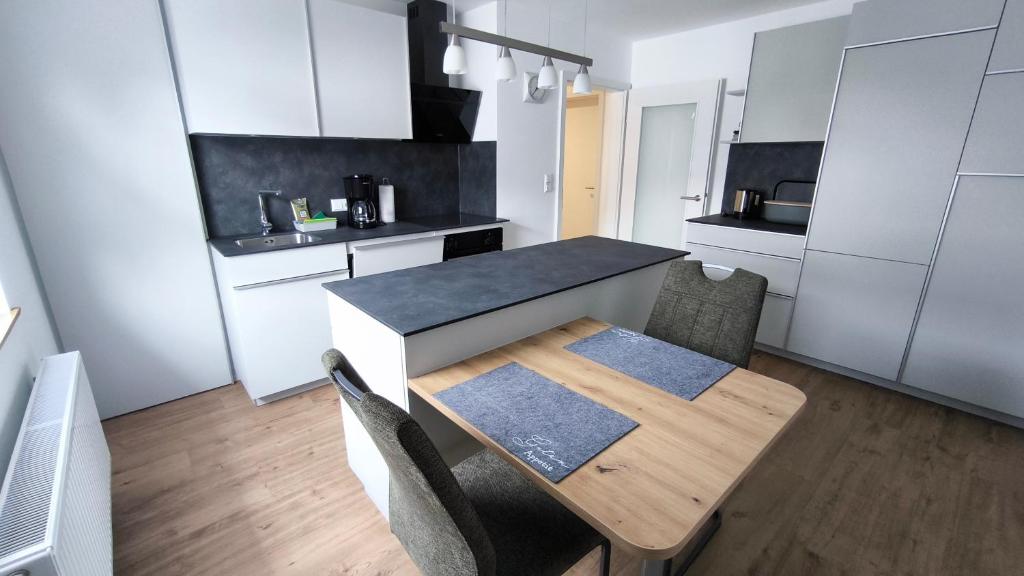 a small kitchen with a wooden table and chairs at Anita's Fewo in Ulm