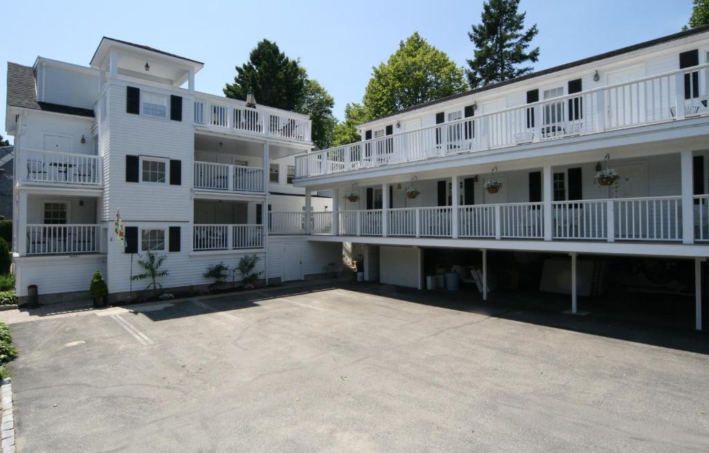 a large parking lot in front of a white building at Eagle House Motel in Rockport