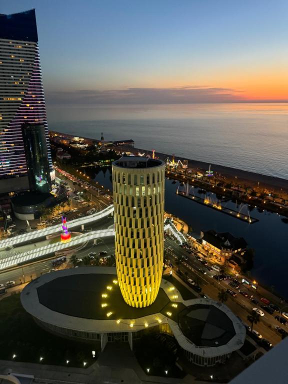 a view of a tall building at night at Alliance Palace in Marriott in Batumi