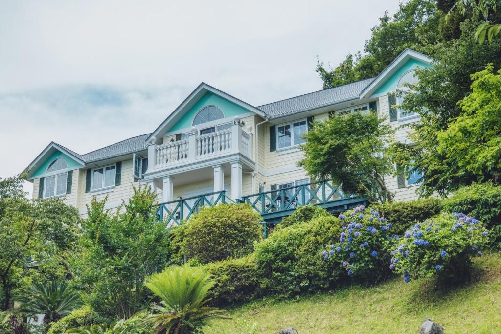 a large house on a hill with bushes at 伊豆集 Episode IZU in Ito