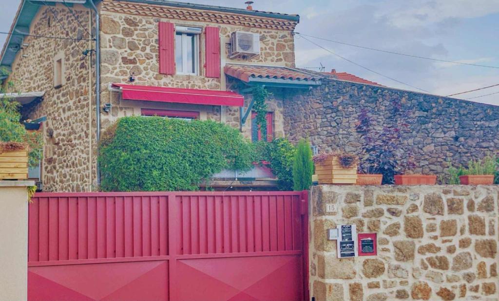 a house with a red gate and a stone wall at LES RÊVES D'EGLANTINE chambres d'hôtes chez l'habitant in Saint-Cyr