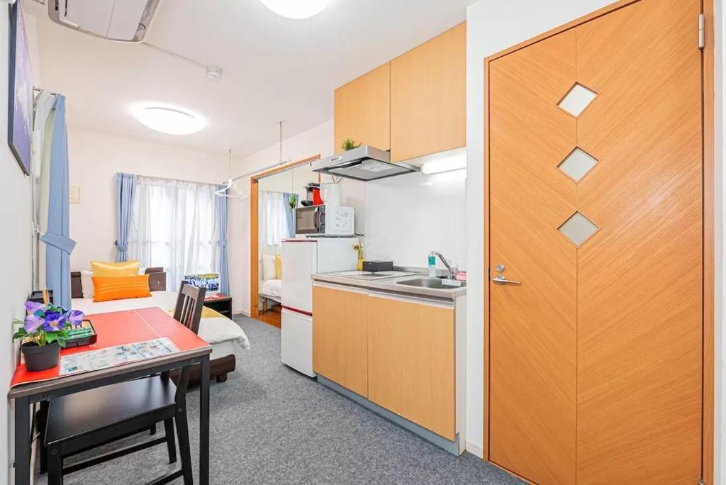 a kitchen with a table and a wooden door at Akihabara Skytree Premium Apartment 201 in Tokyo
