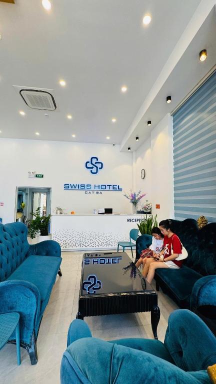 a woman sitting on a couch in a living room at Cát Bà Swiss Hotel in Cat Ba