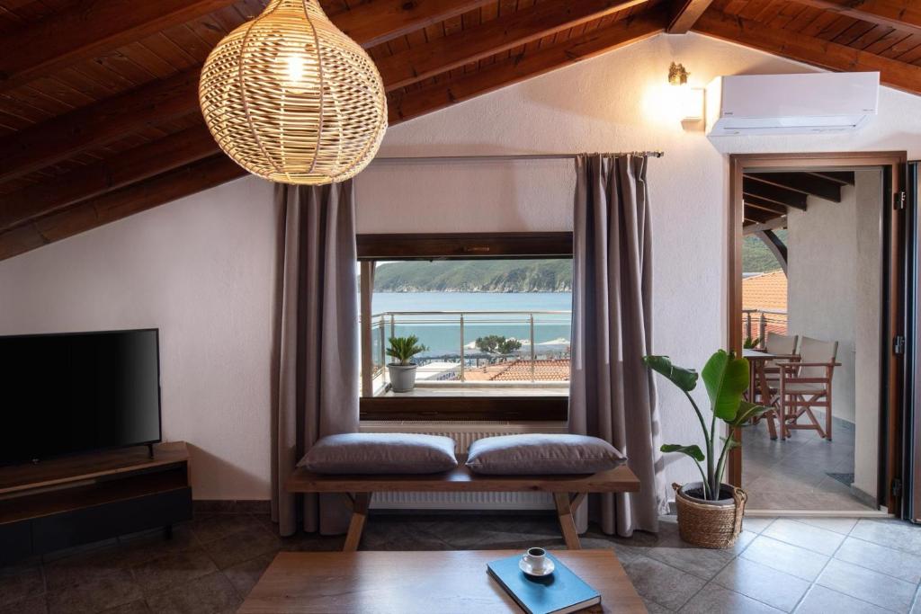 a living room with a couch and a large window at Irene's House Kalamitsi in Kalamitsi