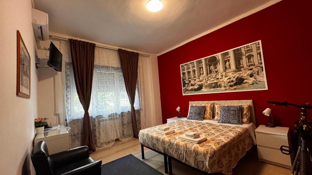 a bedroom with a bed and a red wall at Bella Roma - EE in Rome