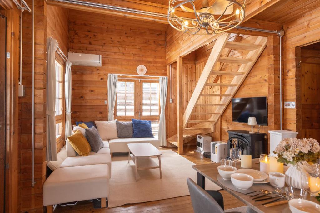 a living room with wooden walls and a staircase at green bell in Myoko
