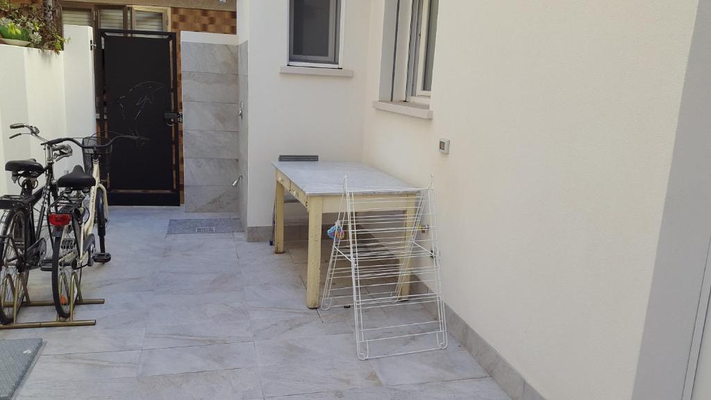 a room with a table and two bikes next to a wall at Casa Delfino in Chioggia