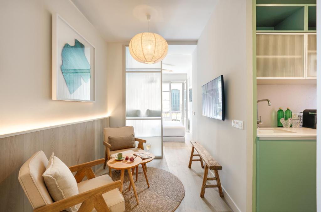 a small living room with a table and chairs at Coeo Frailes Design Apartments in Málaga