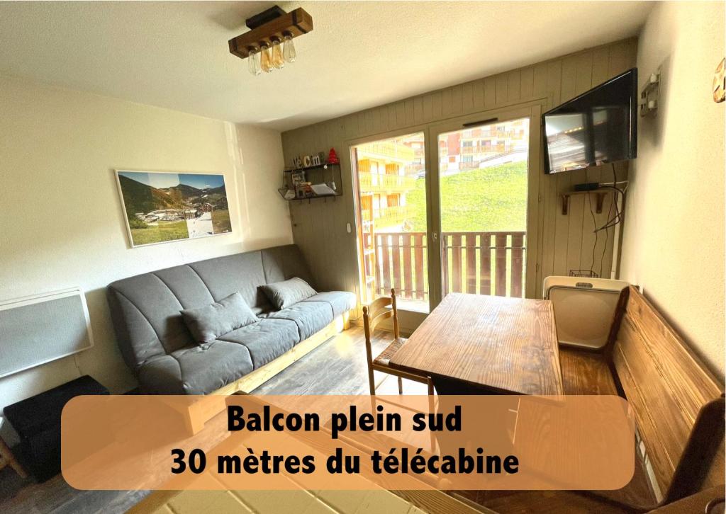 a living room with a couch and a table at Au Pied des Pistes B48, Chaleureux studio 4 pers, balcon plein SUD, DRAPS NON COMPRIS in Saint-Jean-dʼAulps