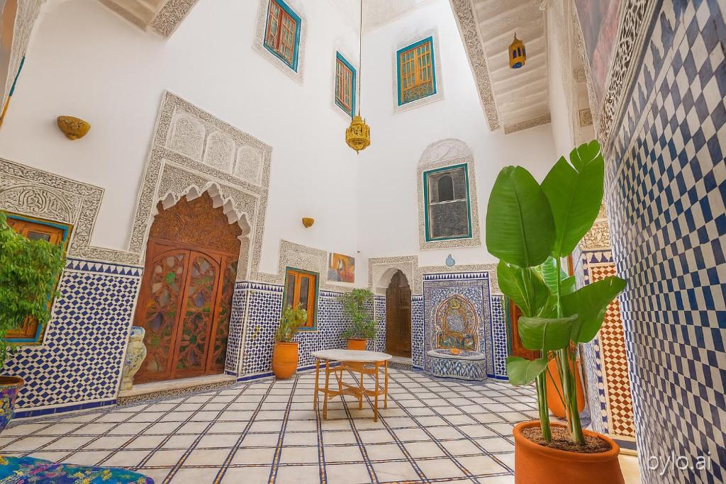 a room with blue and white tiled walls and a table with plants at Riad Rayhana-Exclusive Riad Experience in Fes Medina in Fès