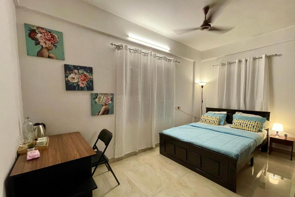 a bedroom with a bed and a desk in it at Cozy Corner in Bengaluru