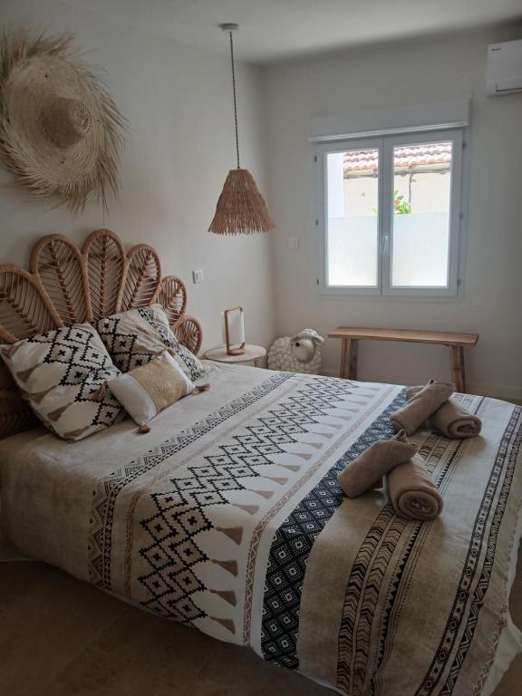 een slaapkamer met een groot bed met een deken erop bij La Bohème in Eyragues