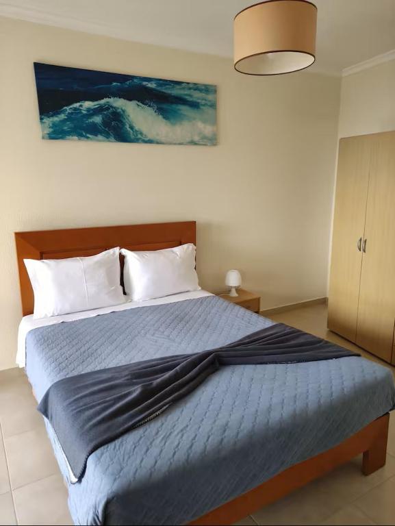 a bedroom with a bed with a blue blanket at Cozy Private Apartment Calheta in Arco da Calheta