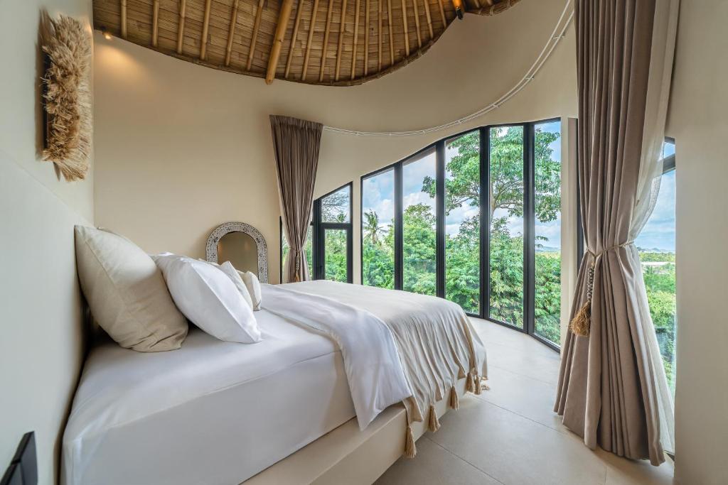 una camera da letto con un letto e una grande finestra di Mambo Villas a Kuta Lombok