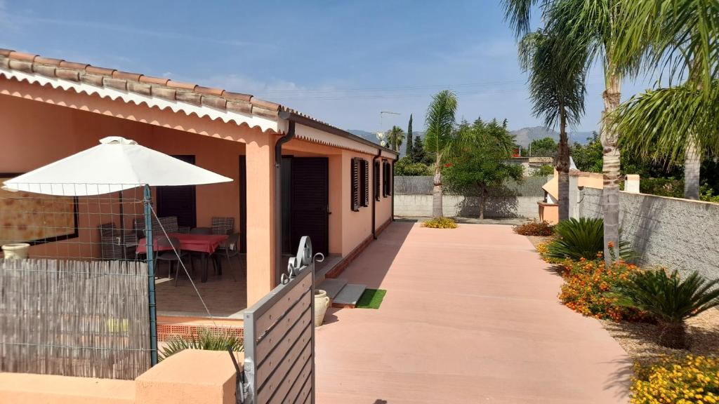 a patio with an umbrella and a house at Casa Maria Teresa in Cardedu