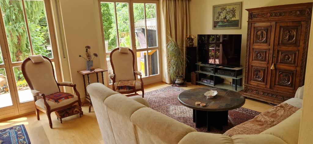 a living room with a couch and a table and chairs at Grünoase vor den Toren Salzburgs in Freilassing