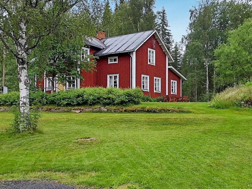 a red house in the middle of a green yard at 8 person holiday home in Östmark in Östmark