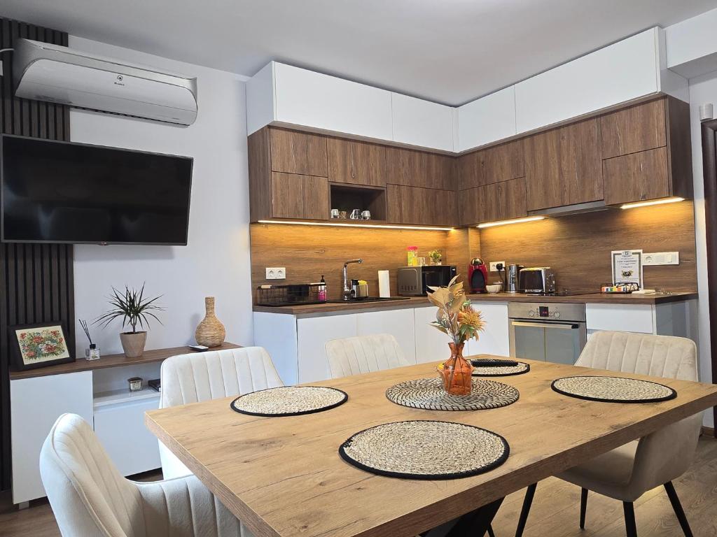 een keuken met een houten tafel en witte stoelen bij Апартамент Дар in Belogradchik