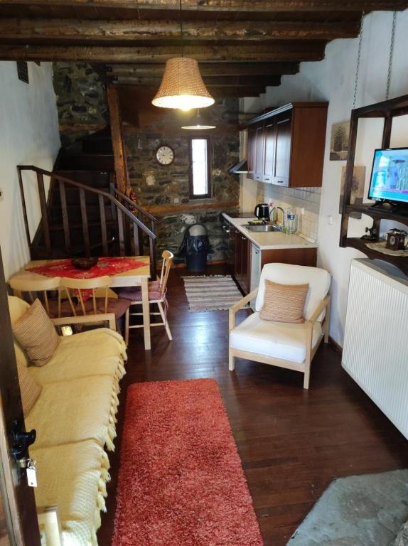 a living room with a couch and chairs and a kitchen at Villa Aretousa in Palaios Agios Athanasios