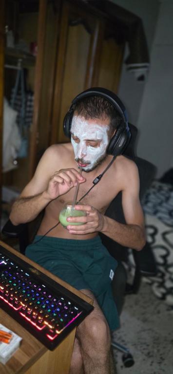 a man with a mask on his face sitting next to a keyboard at Hôtel in Bordj Bou Arreridj