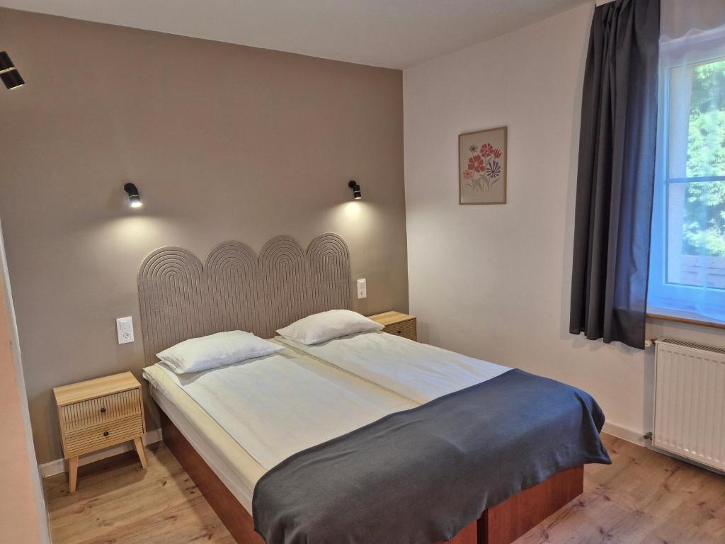 Un dormitorio con una cama grande y una ventana. en Willa Roża Wiatrów, en Karpacz