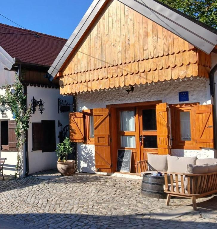 a building with a wooden door and a patio at PodRoom Irena in Zmajevac
